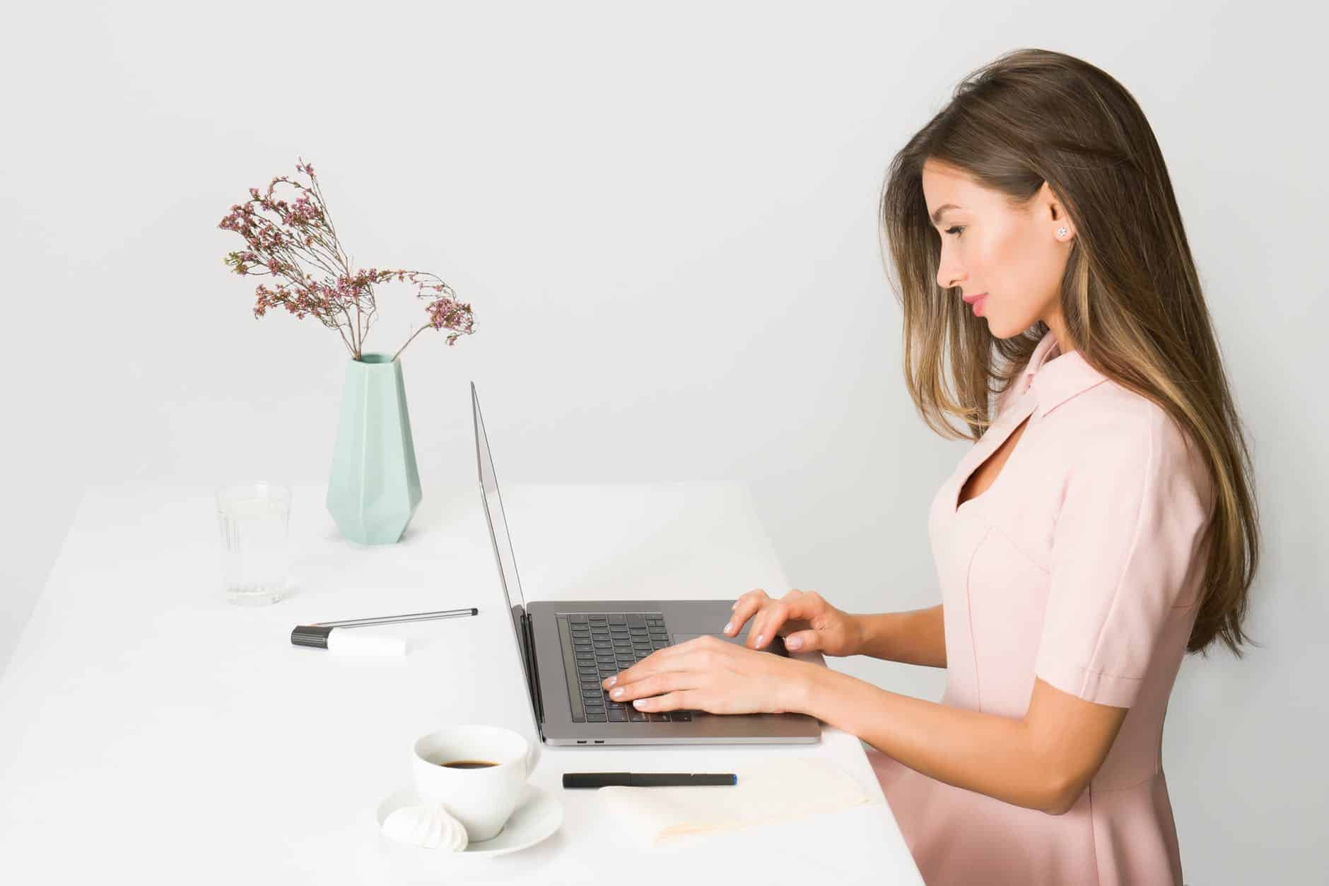 woman in pink dress using laptop computer 3 Types Of Paid Online Surveys You Can Take Right Now